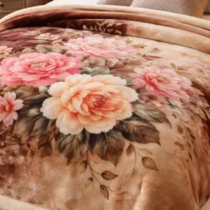 A plush blanket on a bed features a vibrant floral design with large pink and peach roses